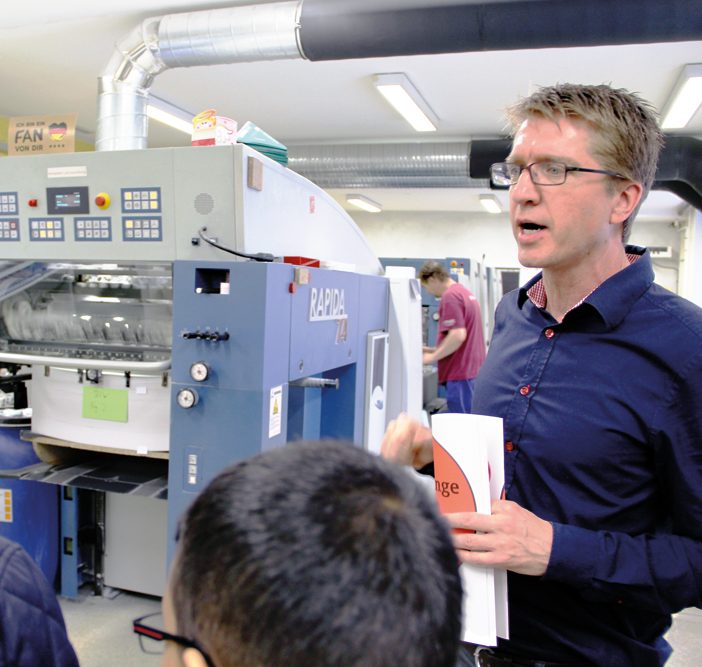 Wolfgang Schulz zeigt einer Gruppe die Druckerei PrintingHouse. Foto: Hensel
