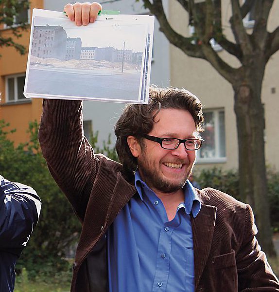 Lothar Gröschel (rechts) hält historische Aufnahmen hoch und zeigt, wie das Viertel vor der Kahlschlagsanierung ausgesehen hat. Foto: Stefanie Ostertag