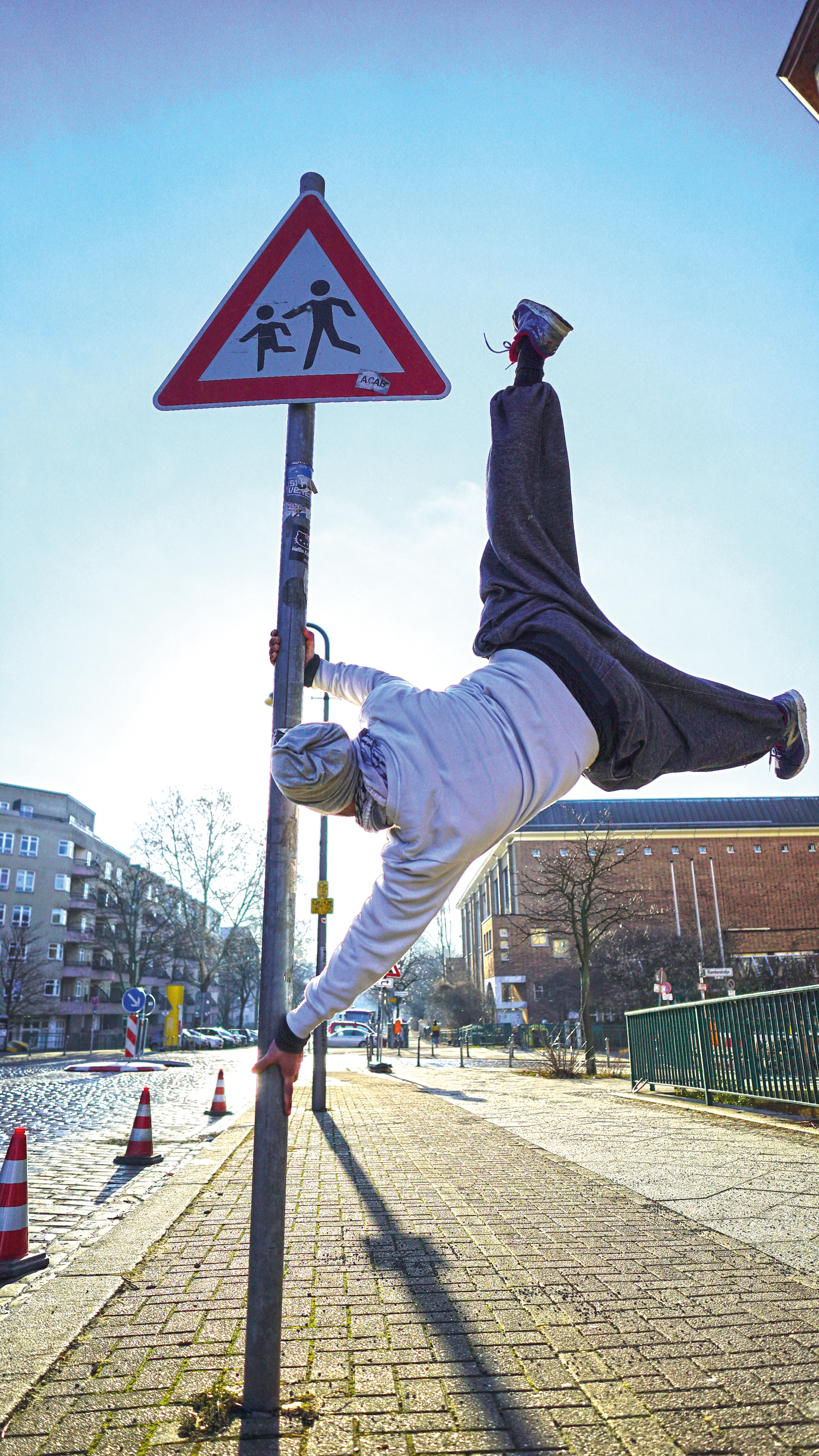 Parkour-Sportler Alex an einem Verkehrsschild vor dem Stadtteilladen des Quartiersmanagements Brunnenstraße. Foto: Paul Alpha