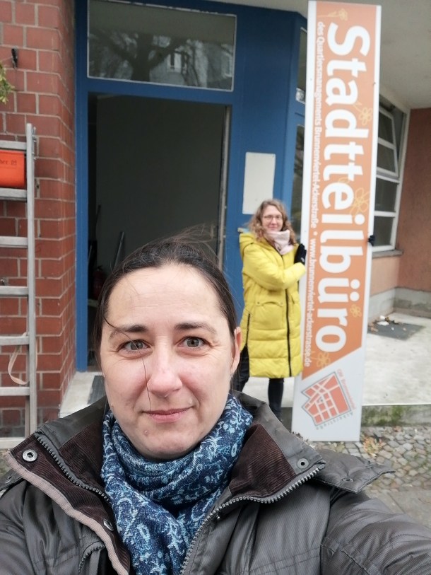 Dominique Hensel von der Bürgerredaktion kam zufällig vorbei und half beim Abschrauben des Schilds des Quartiersmanagement Ackerstraße. Foto: Hensel