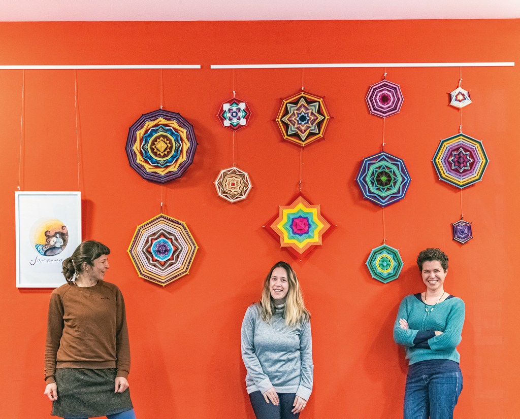 ´Von links: Letícia Utermohl, Daniela Gaeta und Evelyne Leandro vor der Ausstellung mit den Mandalas 
im Olof-Palme-Zentrum. Foto: Isadora Xavier