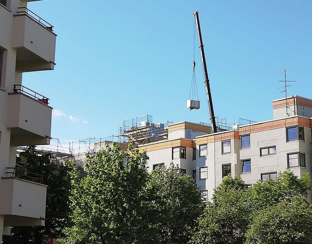 Ein Kran bringt Material für die Sanierung der Wohnhäuser in der Ackerstraße. Die Sanierung hilft auch beim Energiesparen. Foto: Dominique Hensel