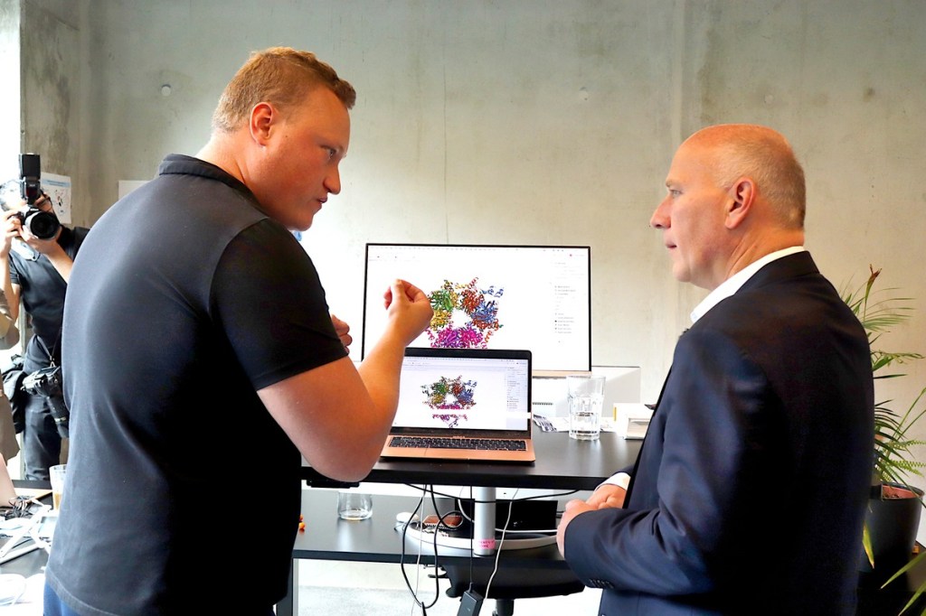 Philipp Markert von exazyme spricht mit dem Bürgermeister Kai Wegner. 
