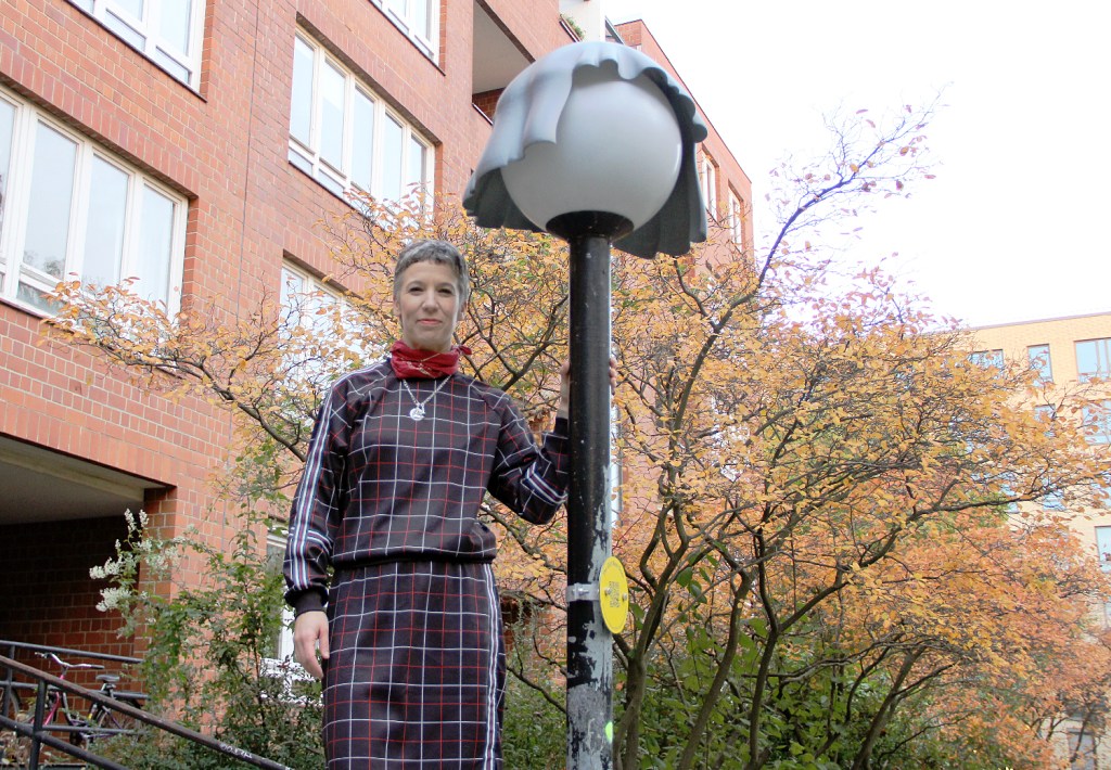 Die Künstlerin Alona Rodeh steht neben einer vor ihr umgestylten Straßenlaterne. Foto: Hensel