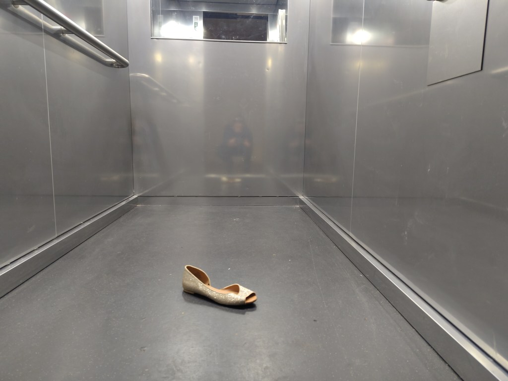 Ein goldener Glitzerschuh im Fahrstuhl. Ein Geschenk? Foto: Hensel