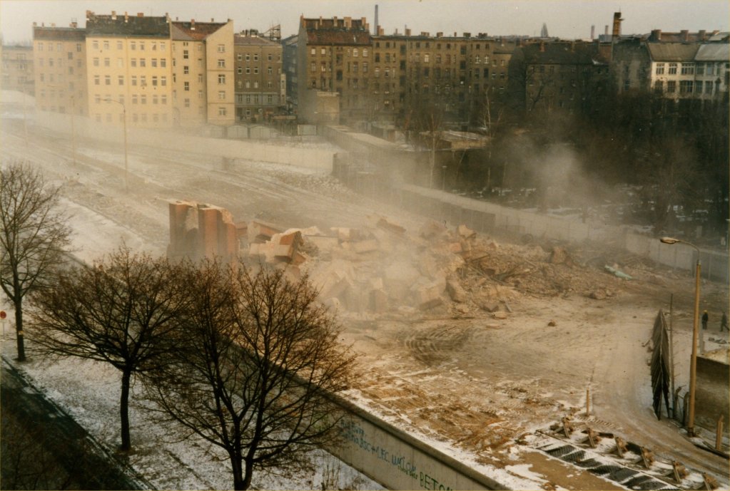 Blick auf den Grenzstreifen an der Bernauer Straße sechs Tage nach der Sprengung des Kirchenschiffs der Versöhnungskirche (28. Januar 1985). Das Foto zeigt den Moment, in dem nun auch der Kirchturm gesprengt und zusammengestürzt ist. Foto: ELAB, Archiv der Versöhnungsgemeinde, Fotograf: Krüger