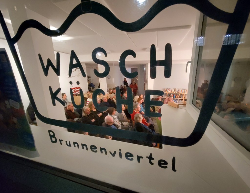 Blick von draußen auf die Lesung in der Waschküche. Foto Hensel