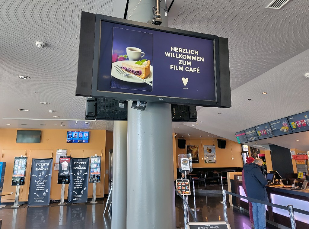 Begrüßung der Gäste auf einem Bildschirm im Kinofoyer. Foto: Hensel