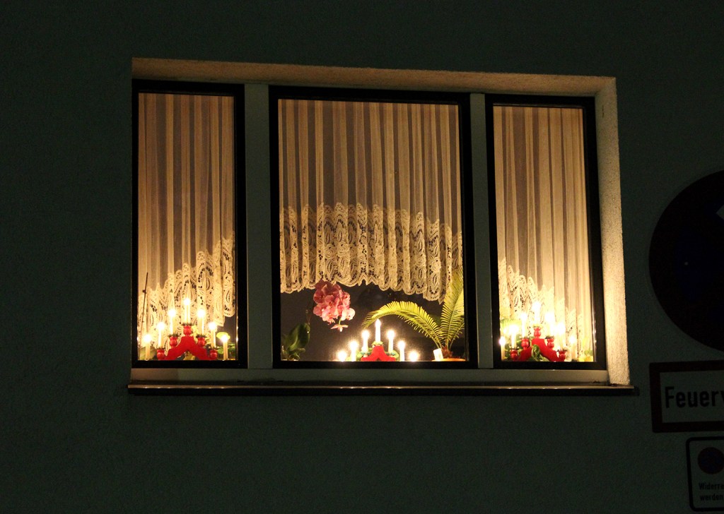 Ein weihnachtlich leuchtendes Fenster in der Nachbarschaft