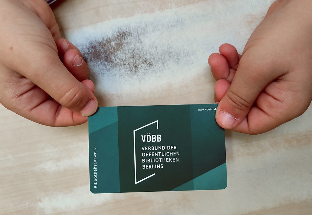 Kinderhände halten eine BibStartCard in die Kamera