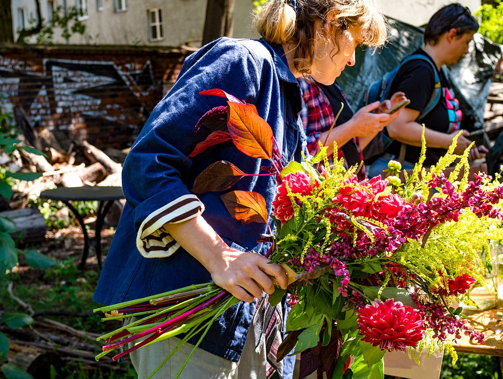 Frau bindet einen Blumenstrauß an einem Tisch im Elisabeet.