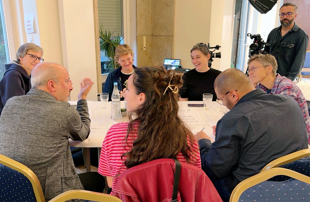 Gäste diskutieren beim Zivilgesellschaftlichen Festakt an einem Thementisch.